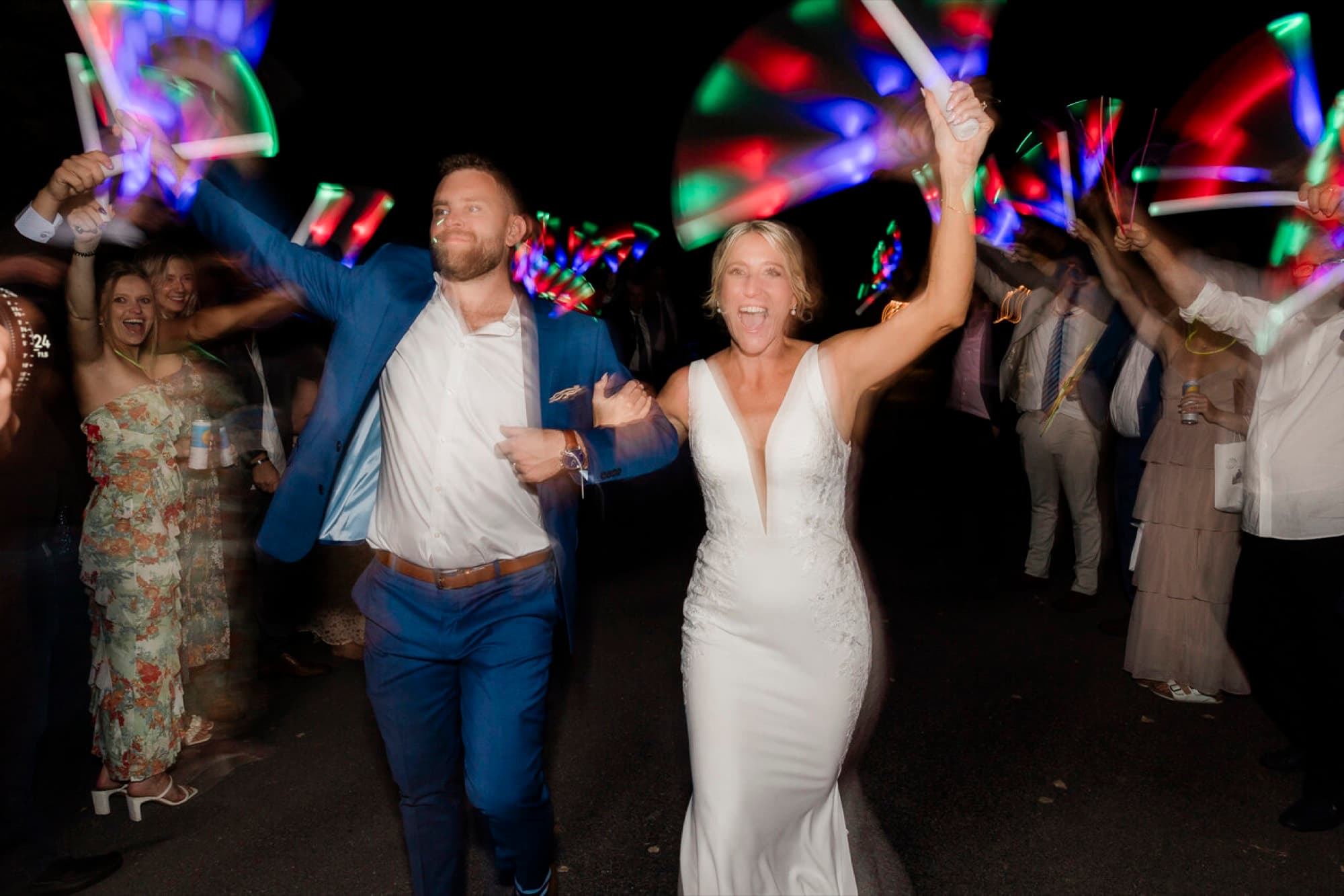 Couple running through a glow-stick send-off